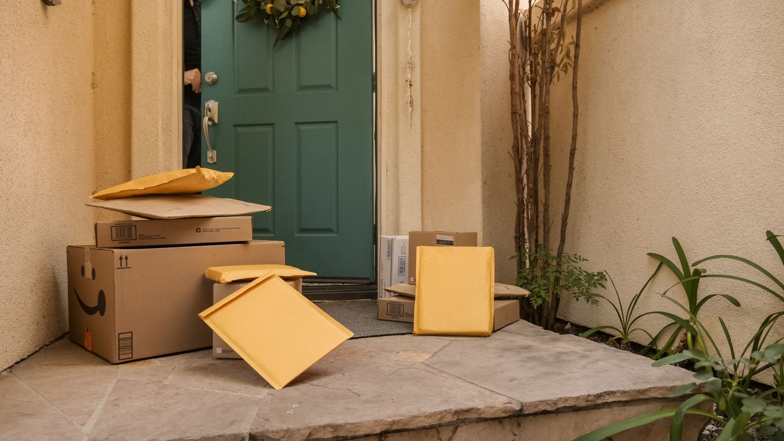 Packages waiting on a stone porch by a green door